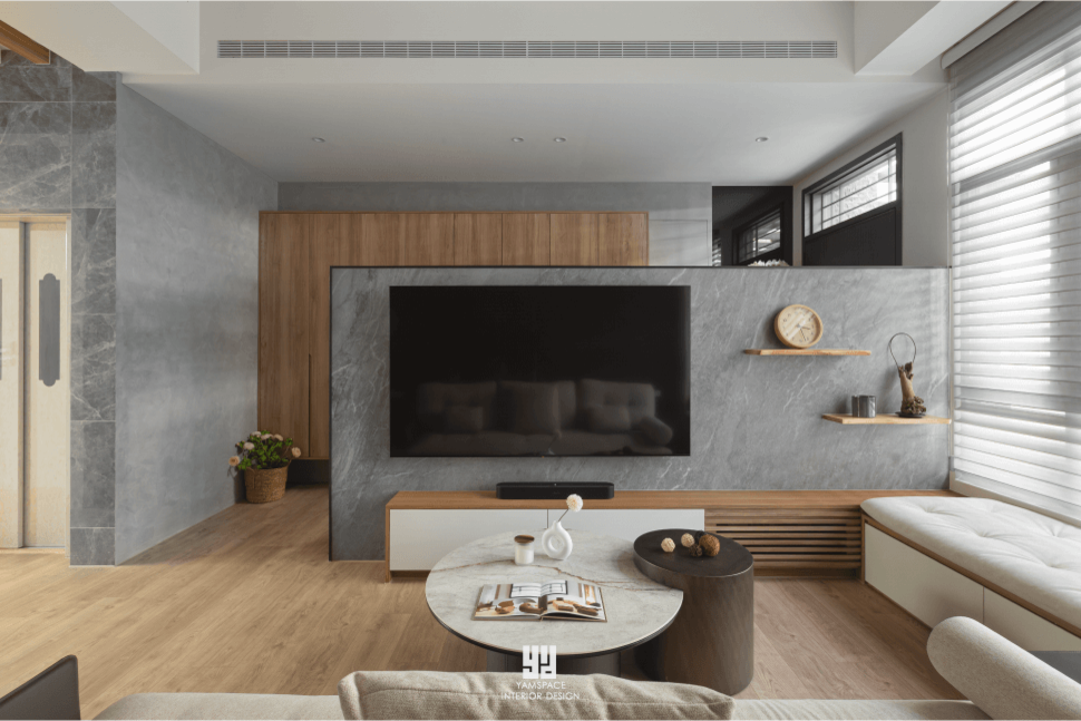 自然木紋與白色櫃體構築通透客廳場域 融合木格柵與白色收納櫃的客廳設計,搭配米白沙發與灰石電視牆,展現清新簡約氛圍