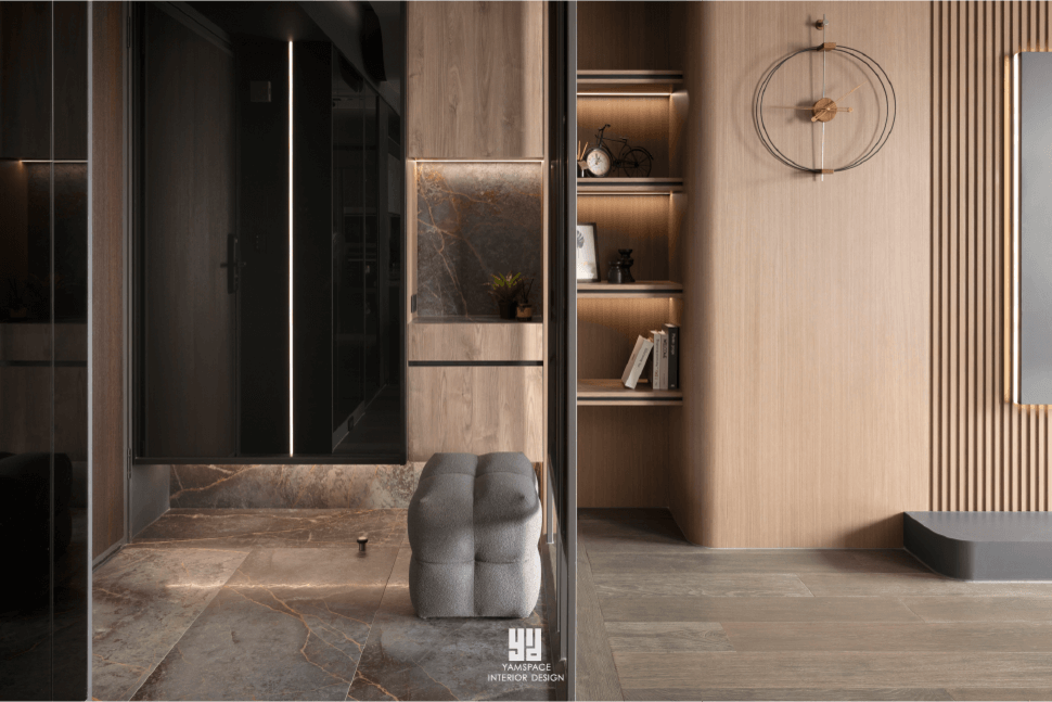 台中芽米新成屋設計|玄關落塵區規劃:深色石材與木質格柵的極簡美學 泰御天鑄室內設計:台中新成屋玄關落塵區,以深色紋理石材地坪銜接溫潤木質格柵牆,結合圓弧曲面收納櫃、穿鞋椅與隱藏式燈帶,形塑現代極簡空間層次感。