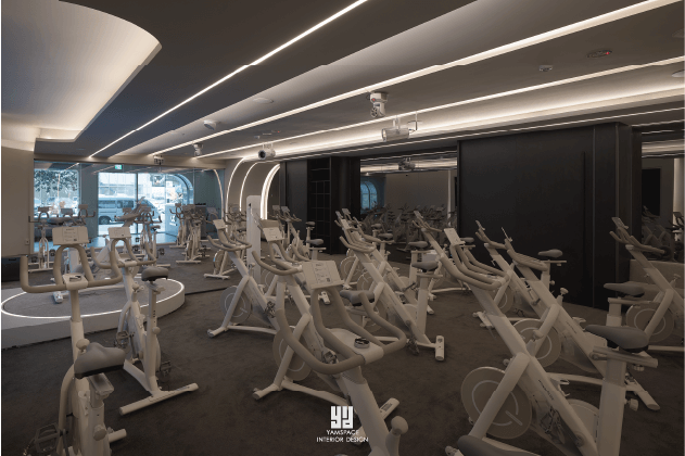 Wondercise健身房內部運動區，全景視角展示了多排白色健身自行車。