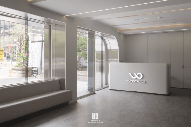 Wondercise健身房的入口，帶有現代感的白色接待櫃檯和寬敞的窗戶。